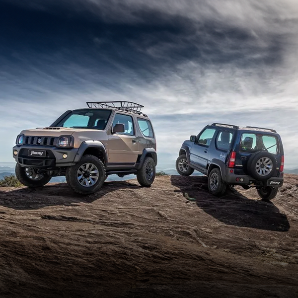 Dois veículos Suzuki Jimny estão estacionados no topo de uma encosta rochosa.