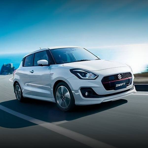 Um suzuki swift branco está dirigindo por uma estrada.