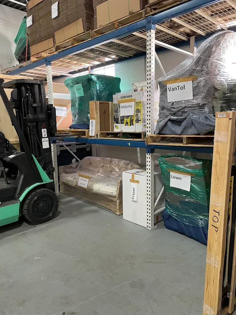 Warehouse shelving with stacked boxes and a forklift in the foreground