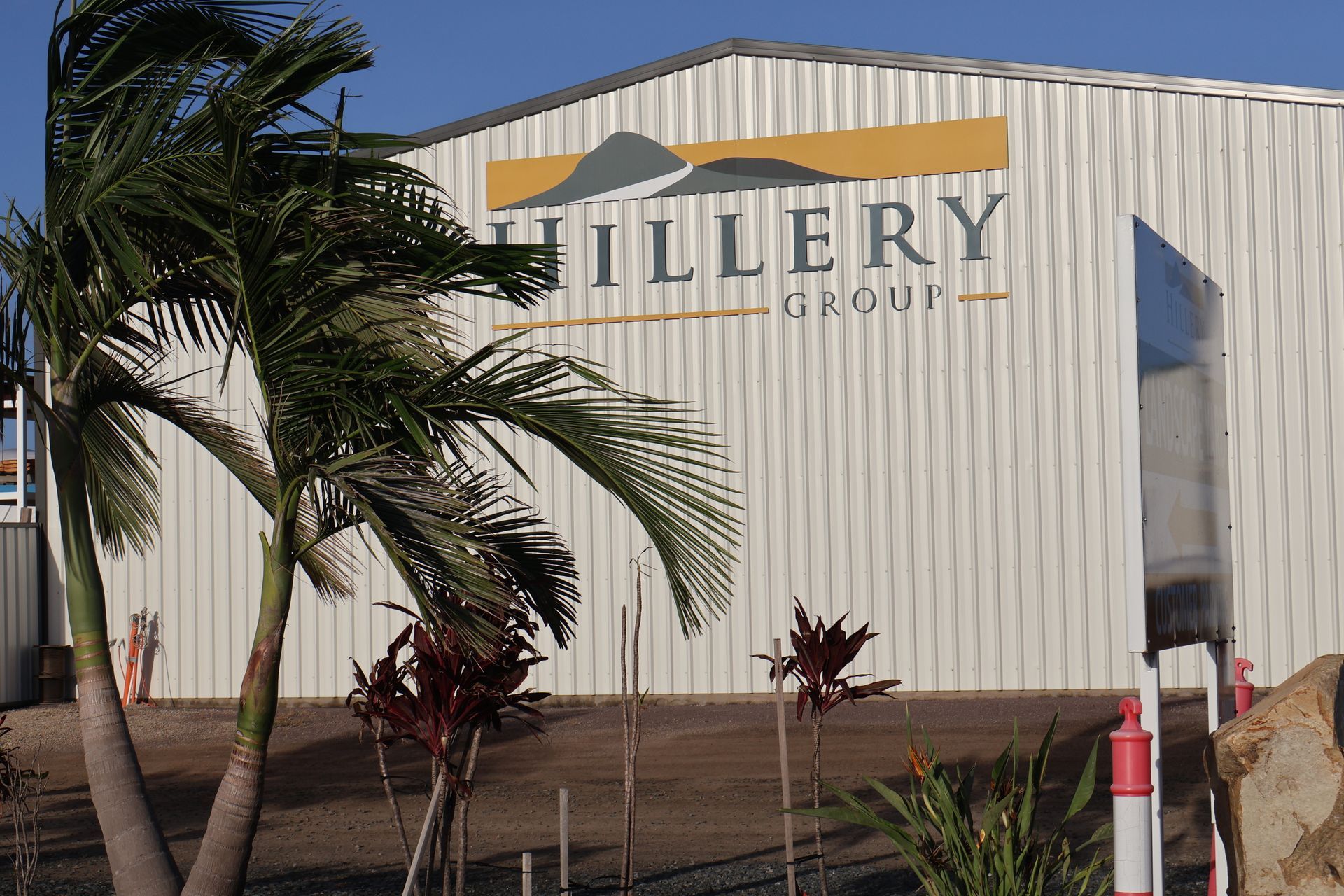 Exterior of a White Art Gallery Building With a Large Palm Tree in Front — Hillery Group in Bowen, QLD