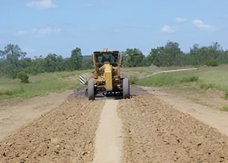 A Tractor Is Plowing a Dirt Road in A Field — Hillery Group in Bowen, QLD