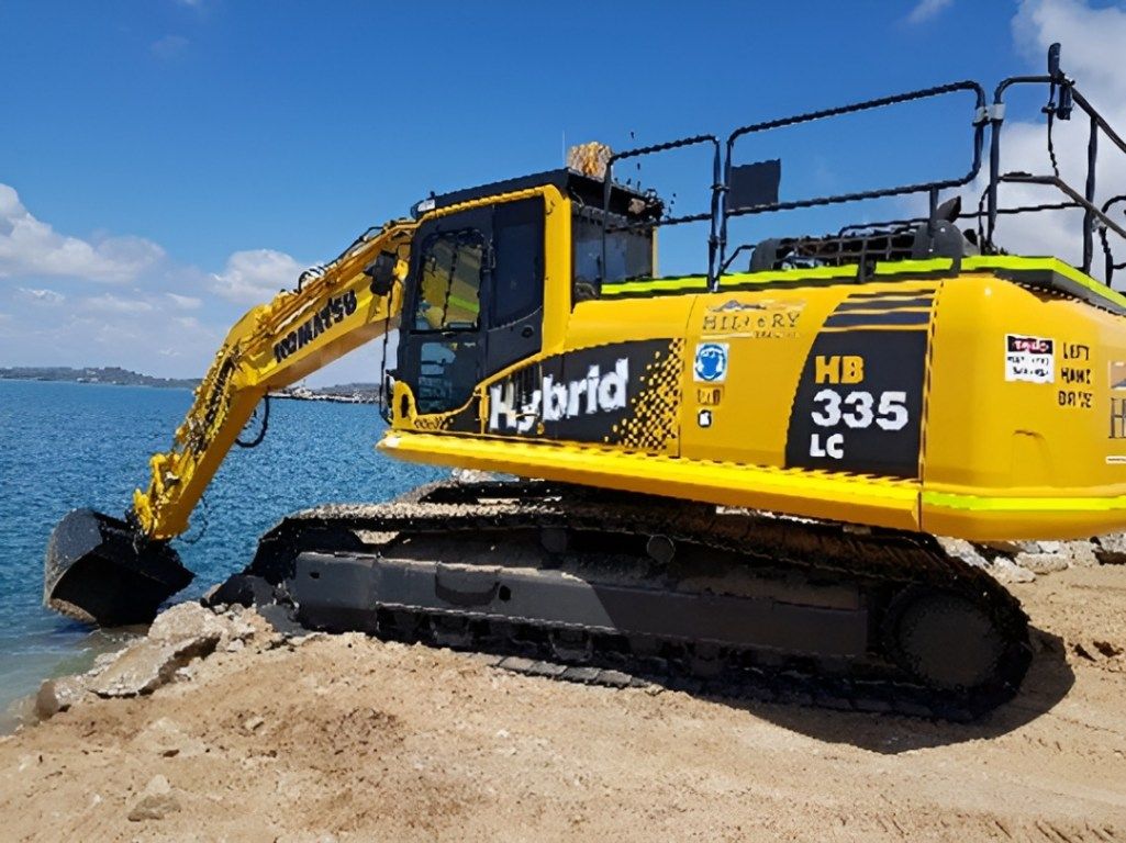 Yellow Excavator Near a Water Body — Hillery Group in Bowen, QLD