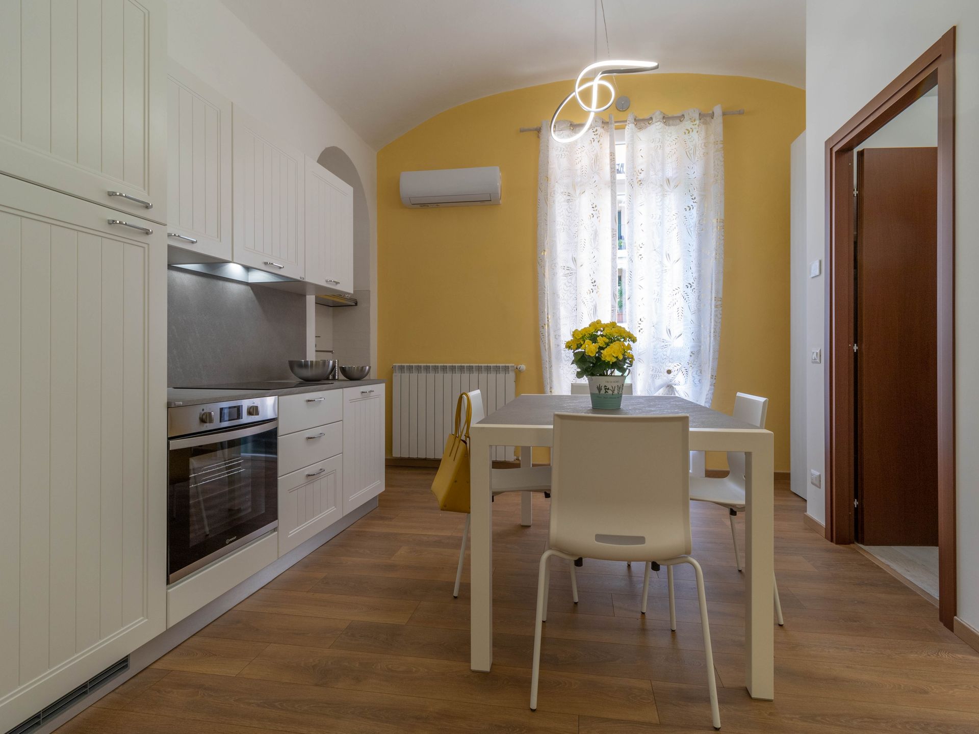 Camera d'albergo pulita e ordinata, con letto matrimoniale, lampada da comodino, finestra e mobili in legno.