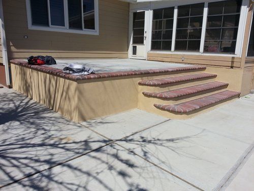 A patio with stairs leading up to a house