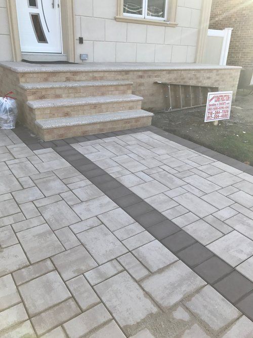 A brick walkway leading to the front door of a house