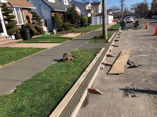 A sidewalk is being built in front of a house.
