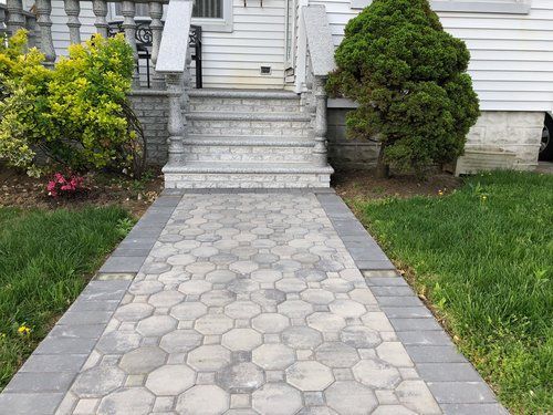 A brick walkway leading to the front door of a house.