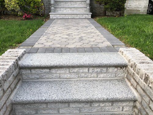 A brick walkway with steps leading up to a house.