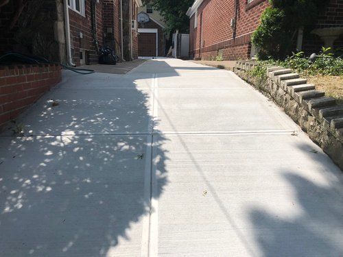 A concrete walkway leading to a brick building.