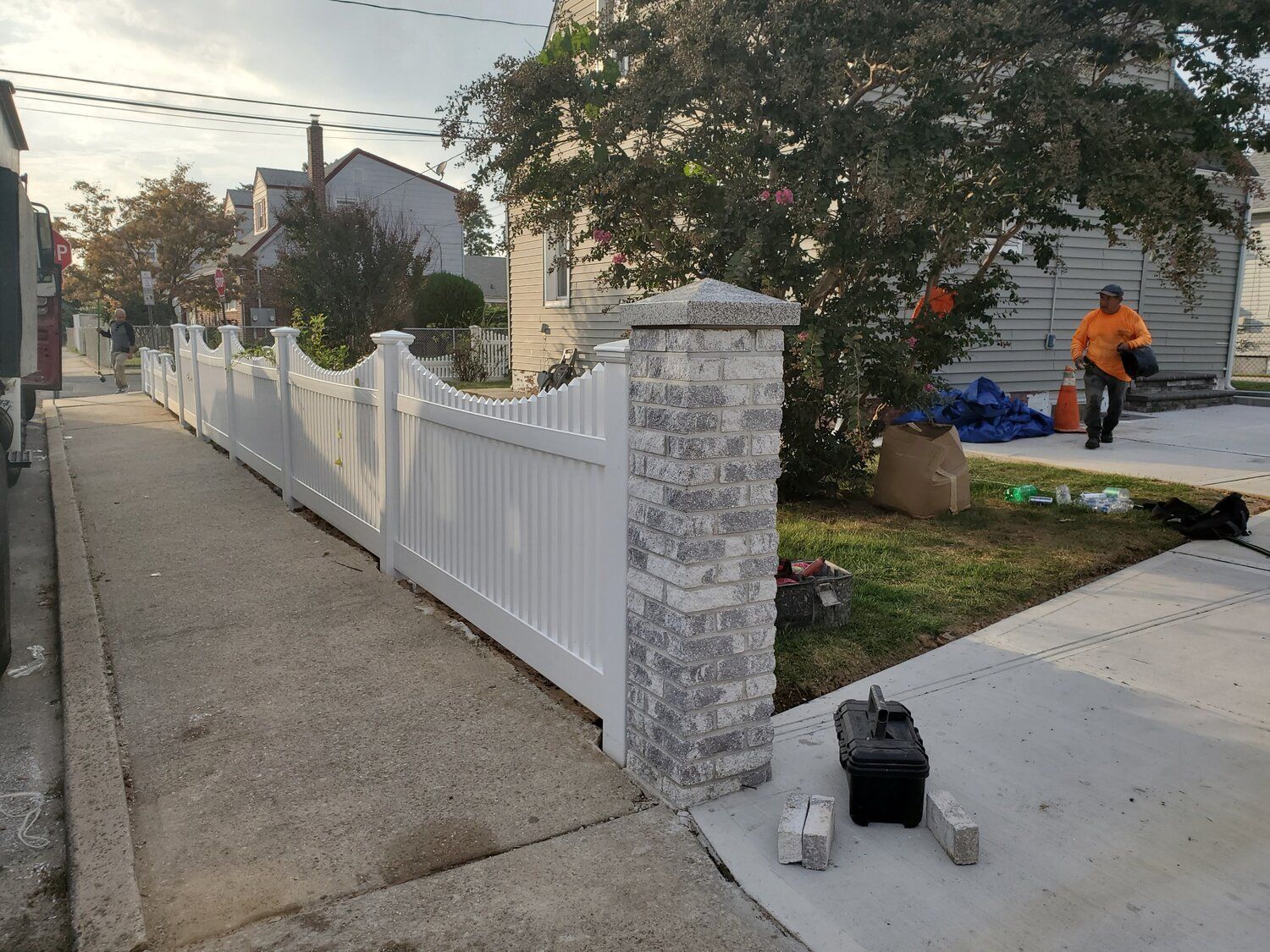 A white picket fence is being built in front of a house.