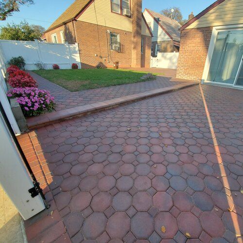 A brick driveway in front of a brick house