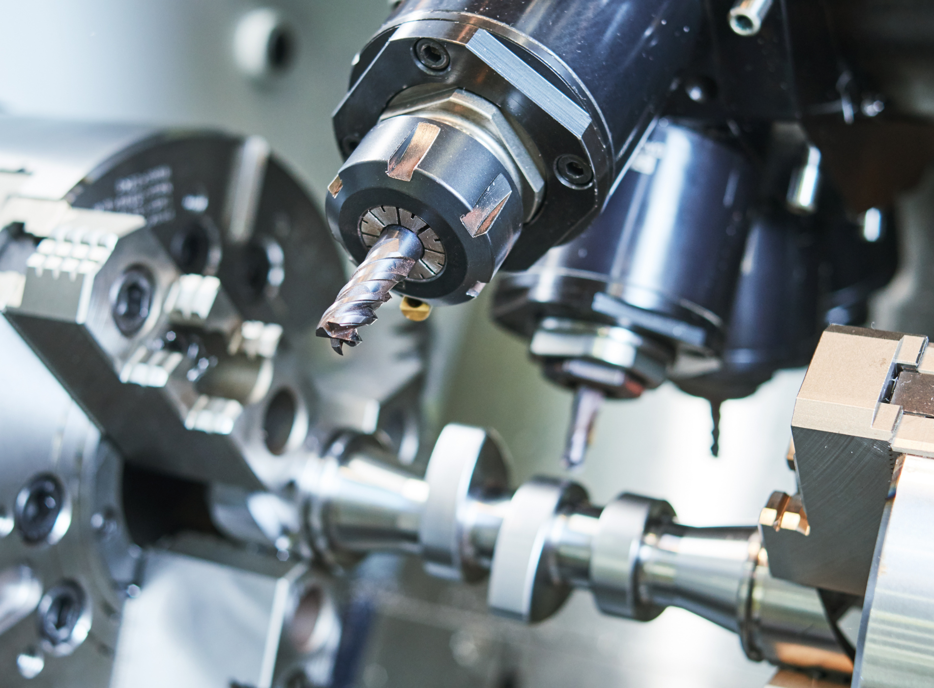 A machine is cutting a piece of metal with a drill bit.