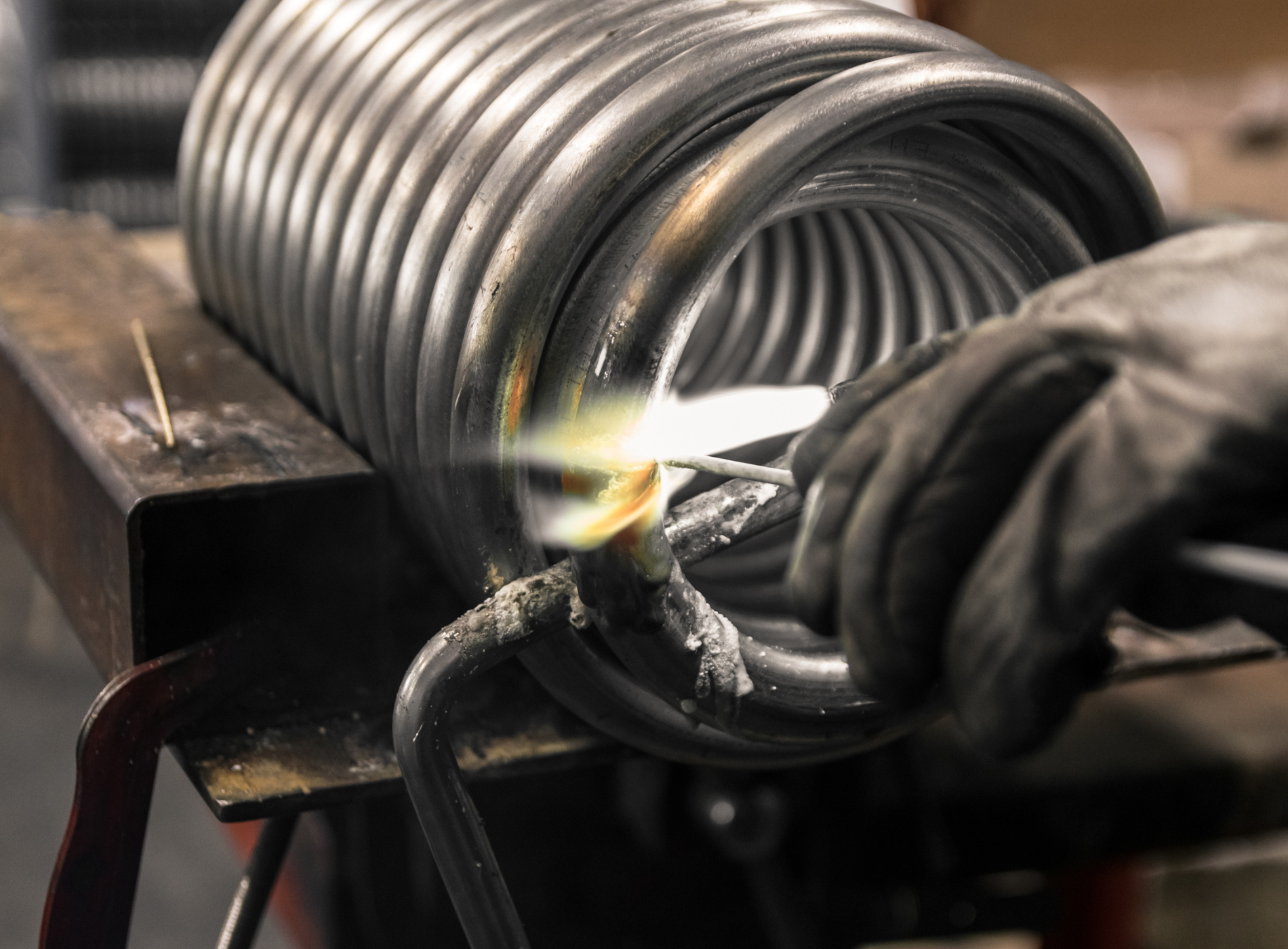 A person is welding a piece of metal on a table.