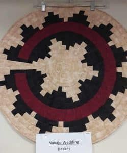 A native american wedding basket is hanging on a wall.