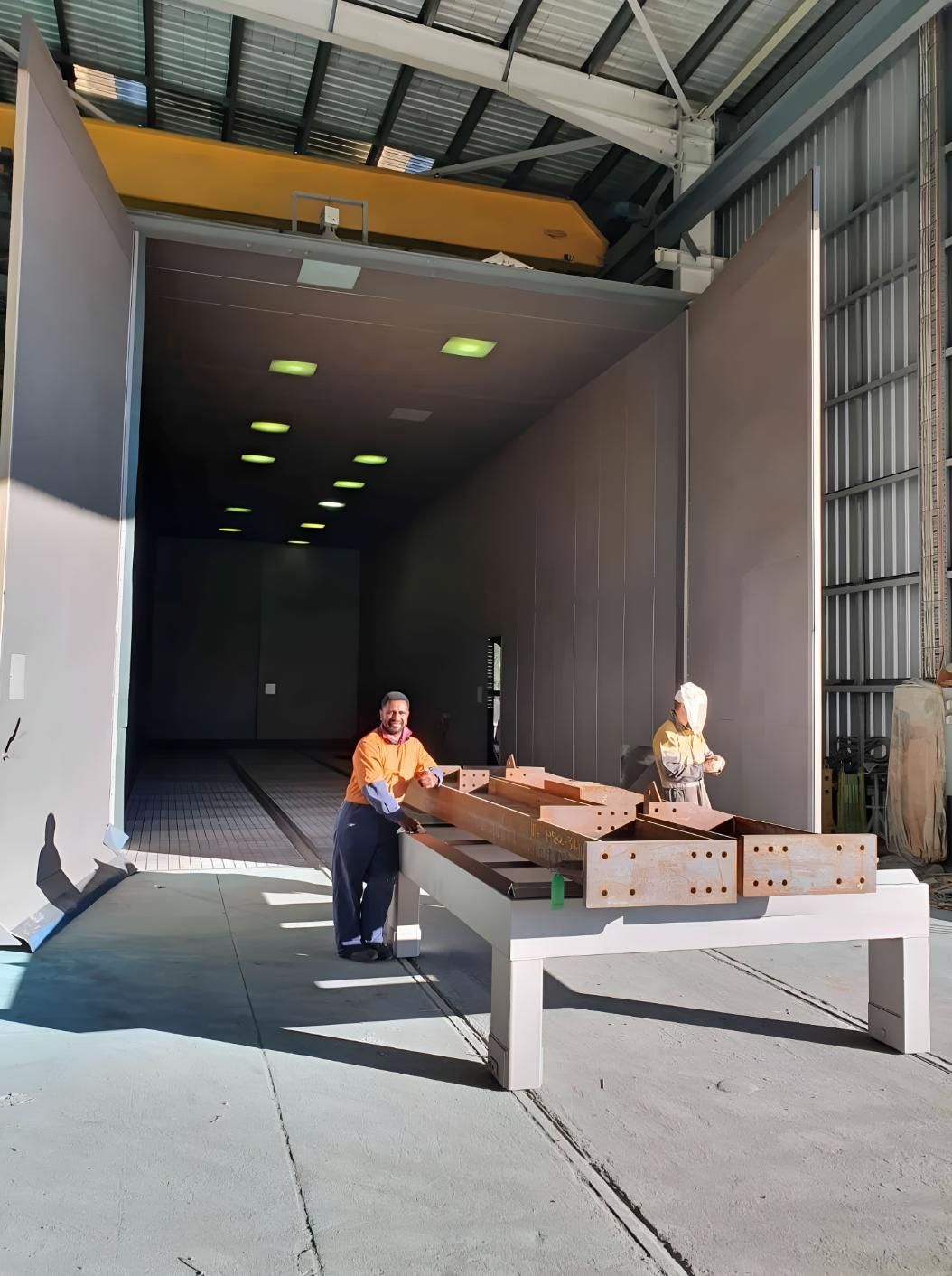 A Man Is Sitting on A Bench in Front of A Large Building — Waters Abrasive Blasting Services in Shaw, QLD