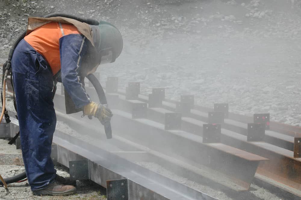 Person Sandblasting Steel Beams — Waters Abrasive Blasting Services In Shaw, QLD