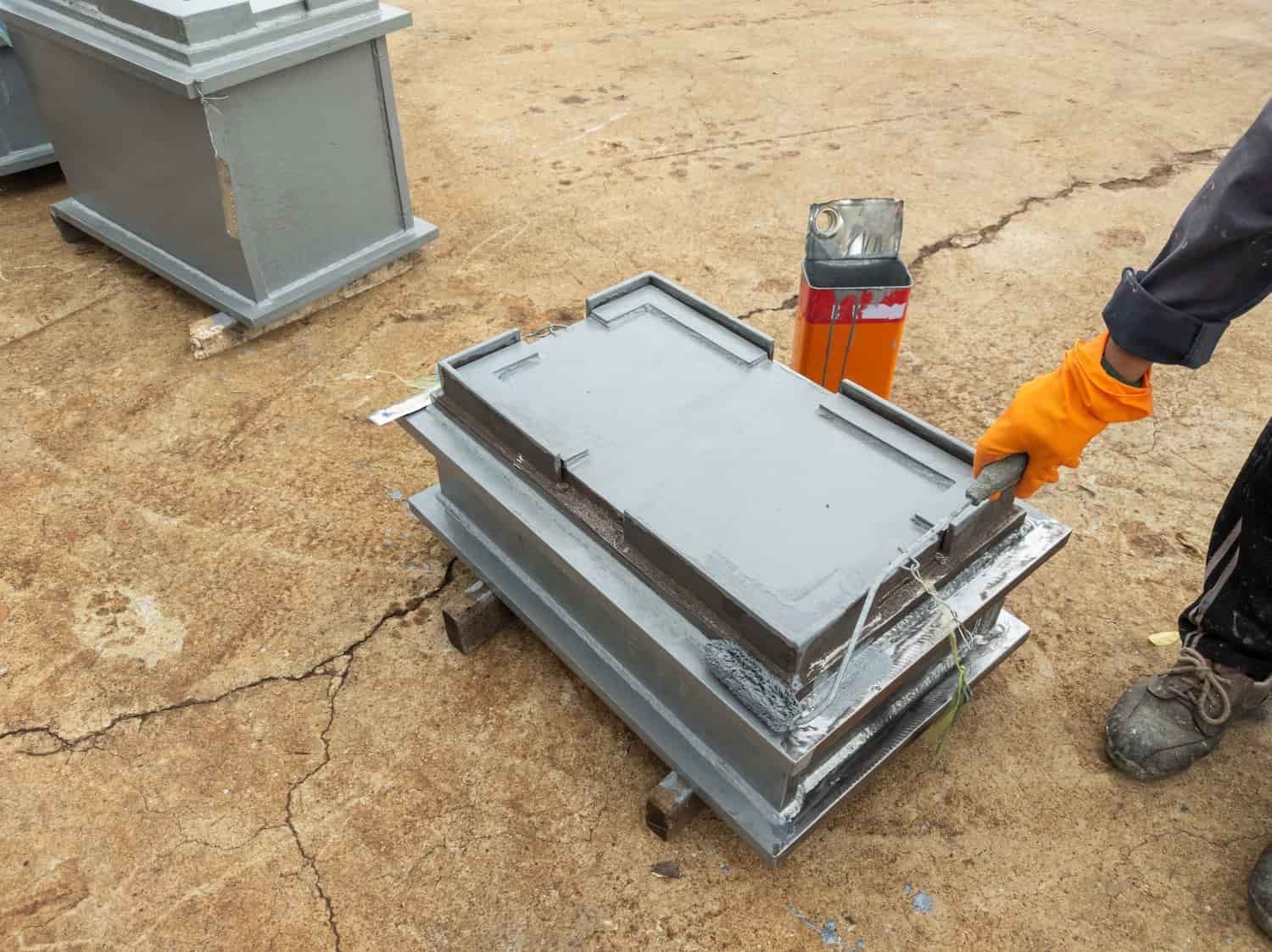 A Person Wearing Orange Gloves is Holding a Piece of Metal — Waters Abrasive Blasting Services In Shaw, QLD