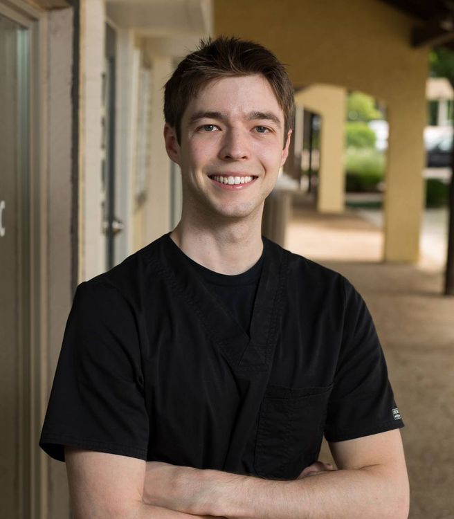 Chiropractor, Dr. Tyler Nigus, stands in front of his Overland Park, KS chiropractic office.