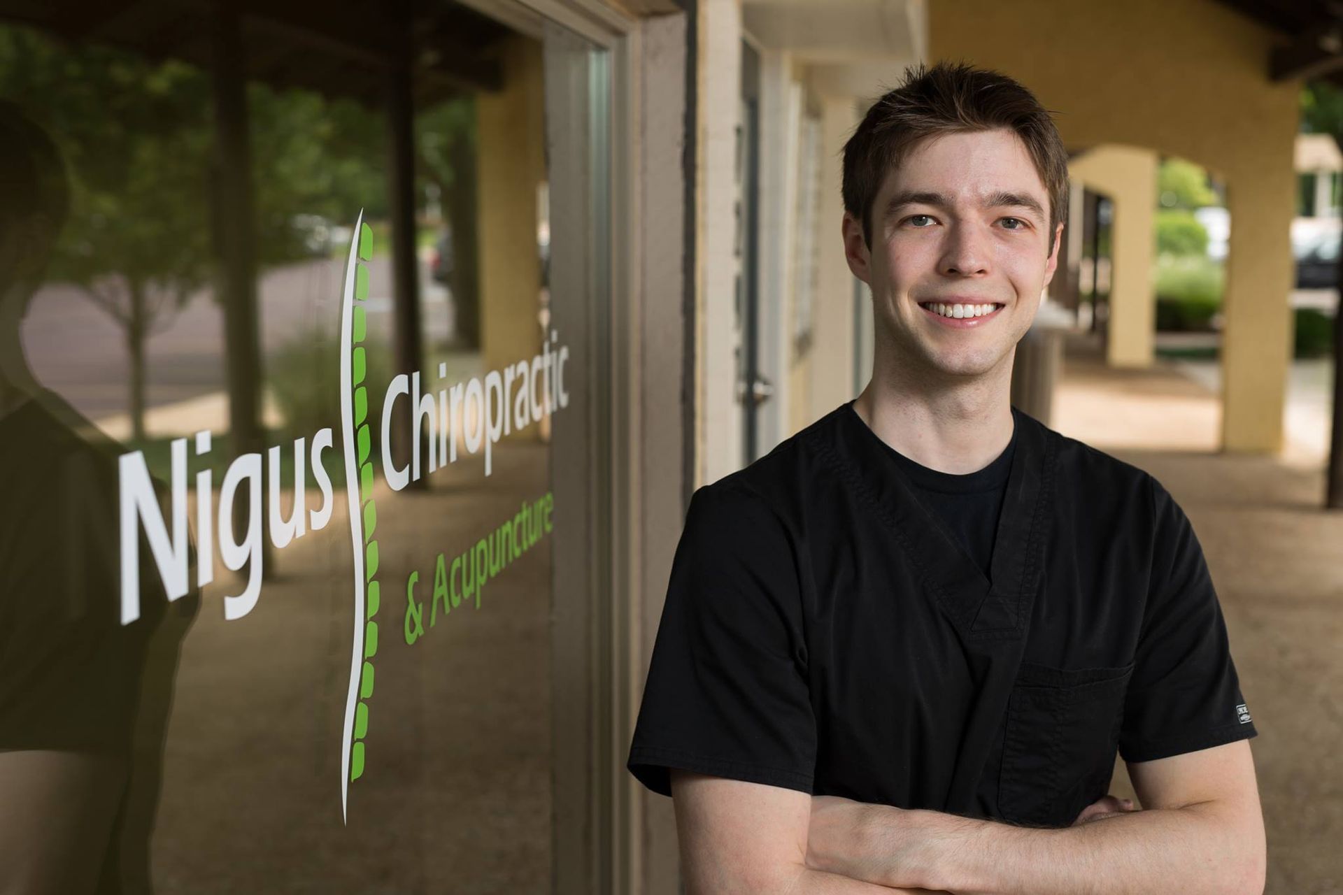 Dr. Tyler Nigus, a chiropractor, stands in front of his Overland Park, KS chiropractic office.