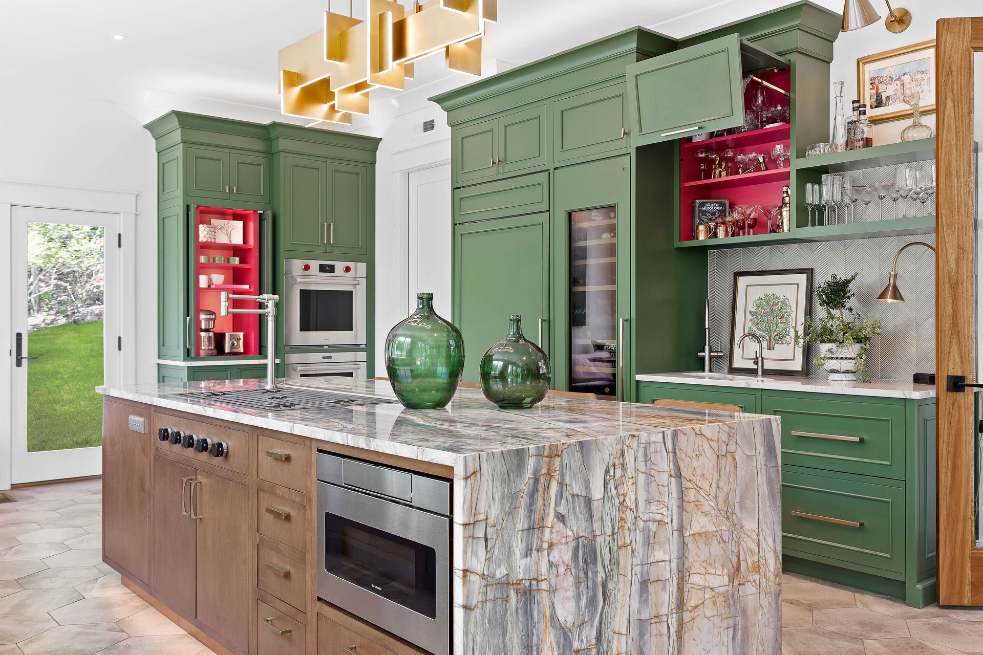 Stylish kitchen with sage green cabinets, wood island, red accents, and marble countertops