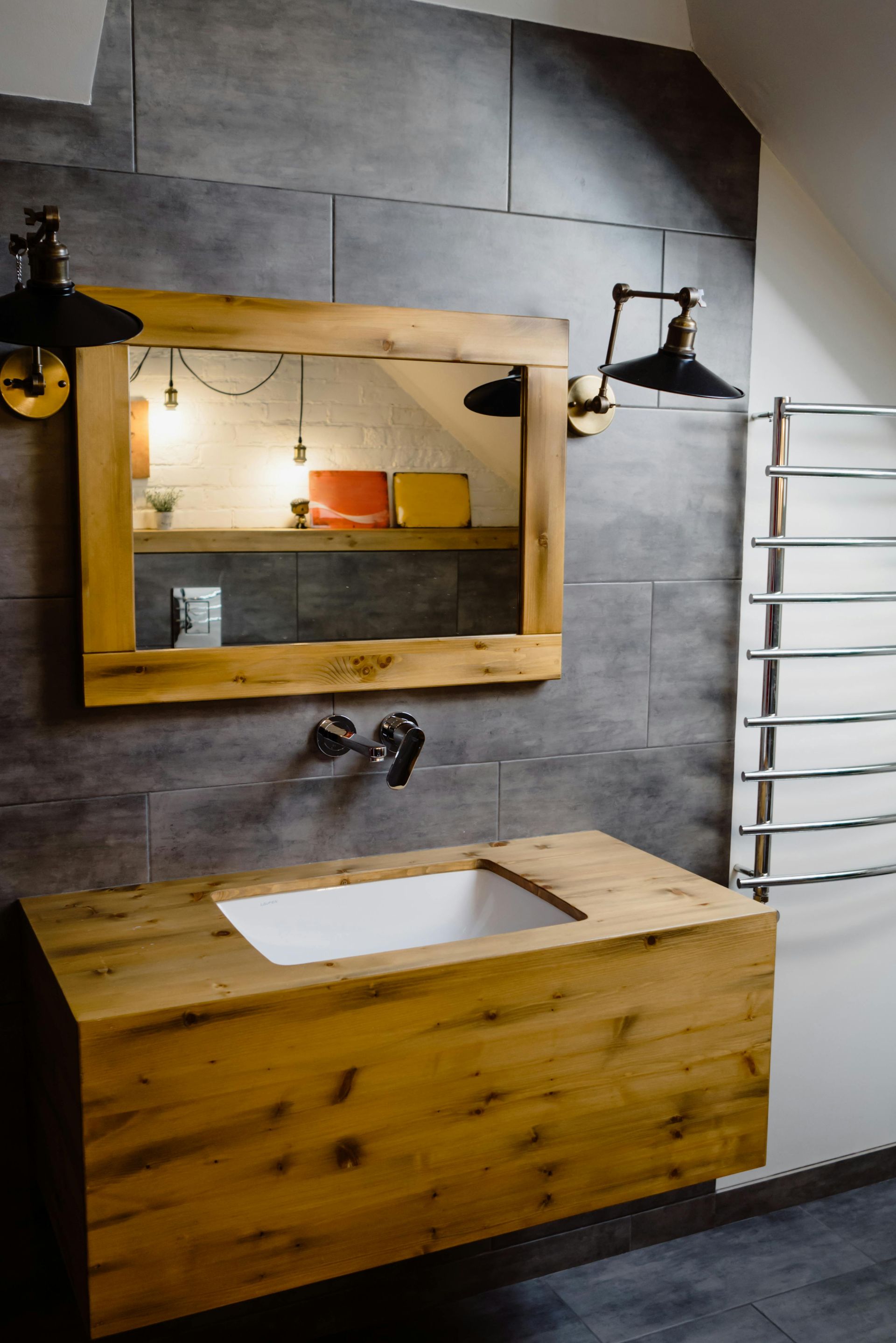 A bathroom with a wooden sink , mirror and towel rack.