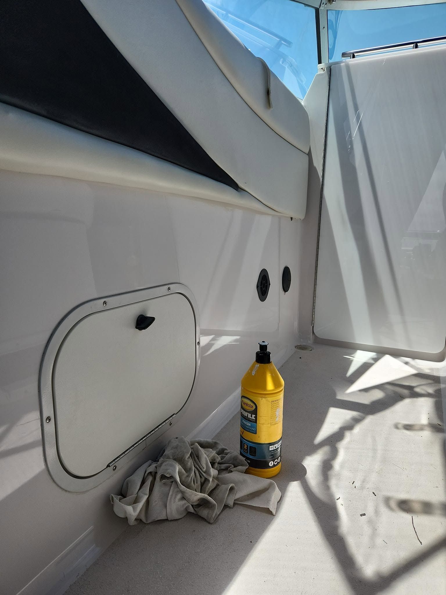 Boat Interior With White Panels, a Yellow Bottle, and Cleaning Rags — Baran Yachting in Sunshine Coast, QLD