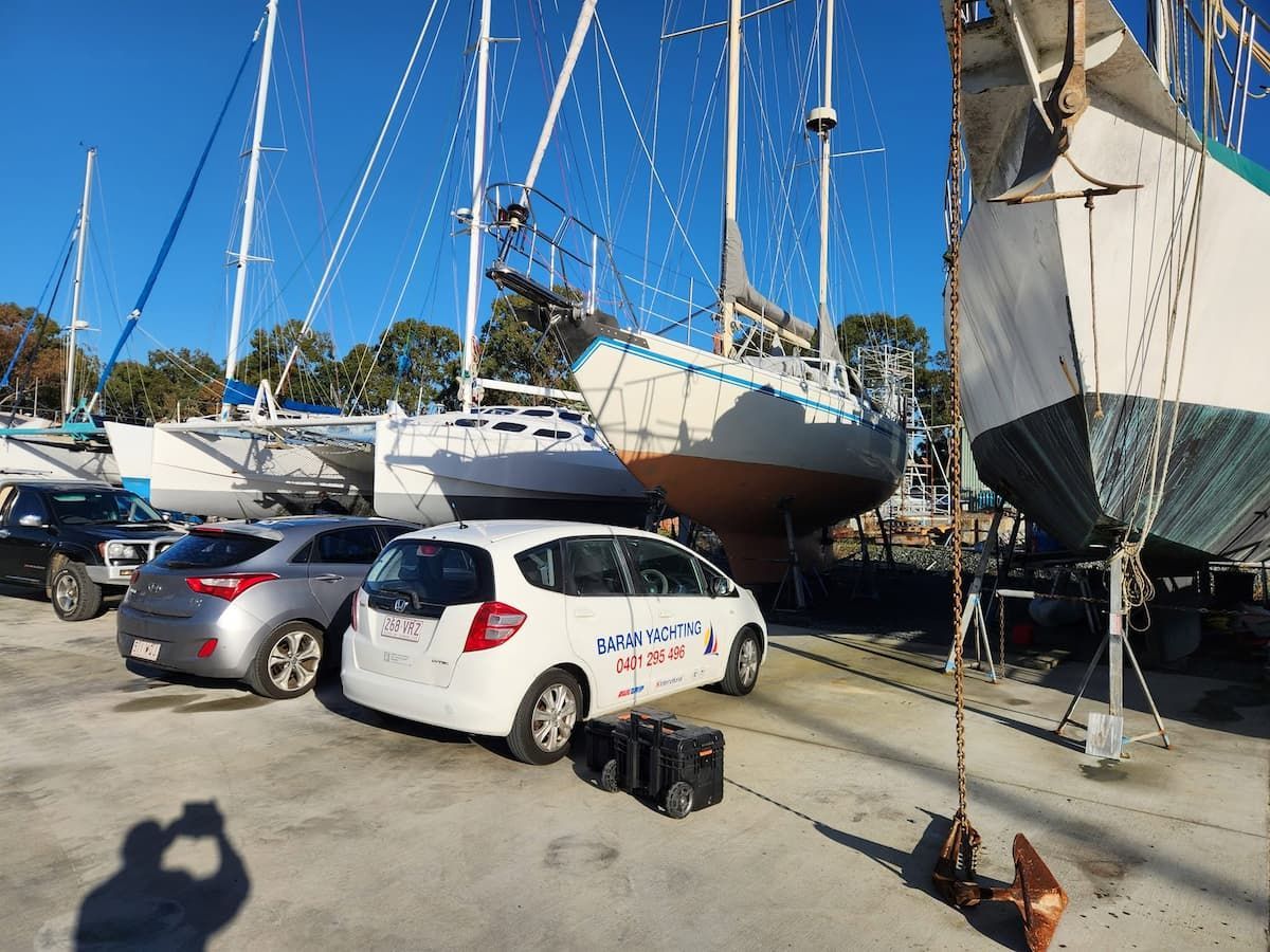 Yachts on Stands in a Marina Lot Beside Parked Cars — Baran Yachting in Buderim, QLD
