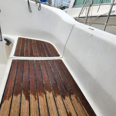 A White Boat With a Wooden Deck and a Wooden Bench — Baran Yachting in Caloundra, QLD
