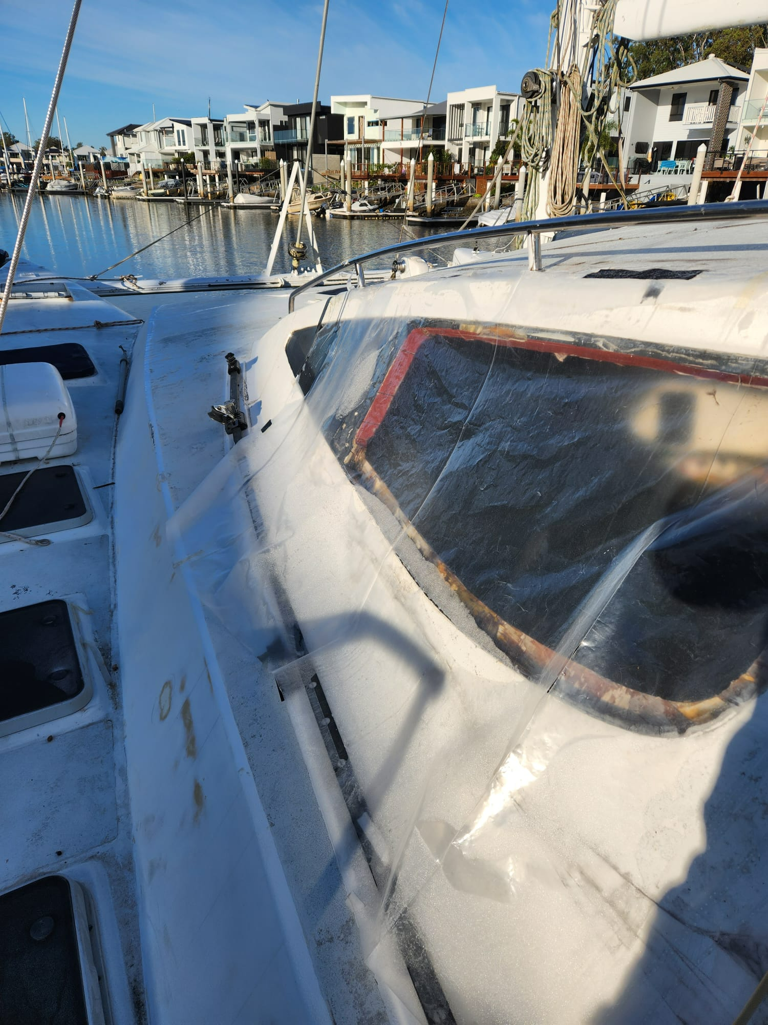 A White Sailboat Is Docked In A Harbor — Baran Yachting in Sunshine Coast, QLD