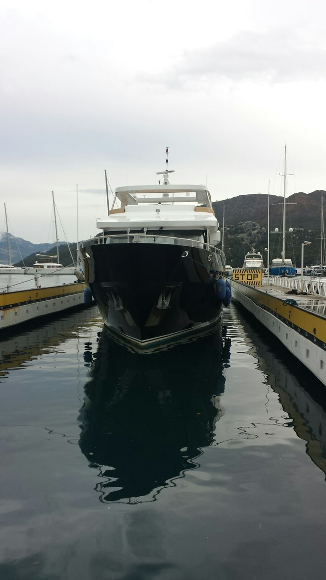 A Large Boat Is Docked In A Harbor With Mountains In The Background — Baran Yachting in Sunshine Coast, QLD