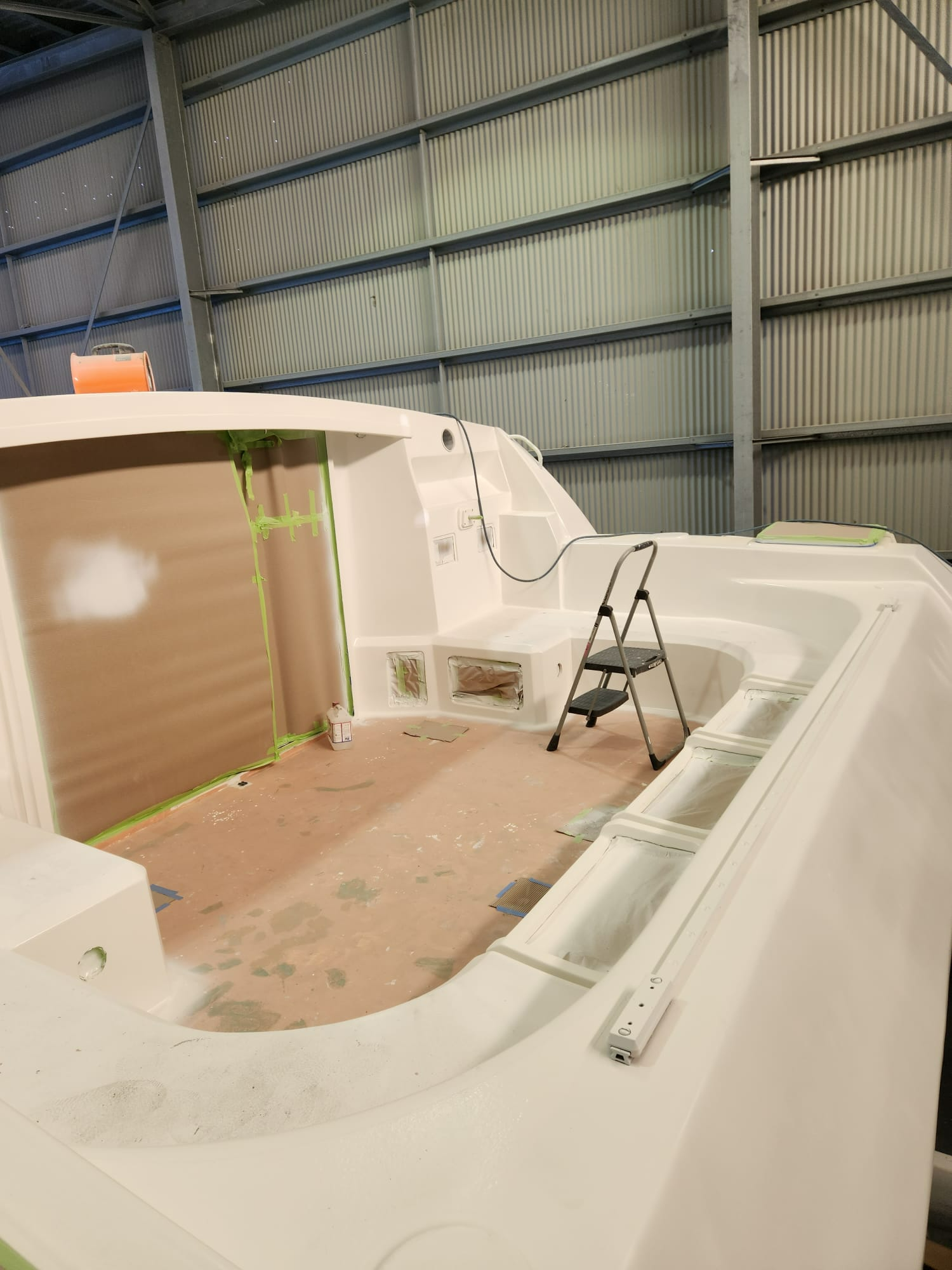 A White Boat is Being Painted in a Warehouse — Baran Yachting in Sunshine Coast, QLD