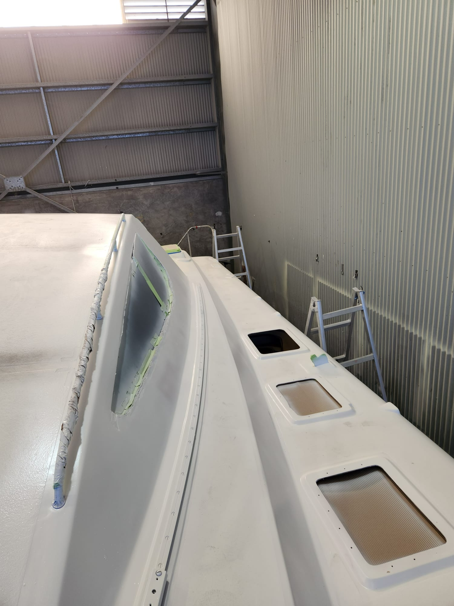 A White Boat is Being Painted in a Warehouse — Baran Yachting in Sunshine Coast, QLD