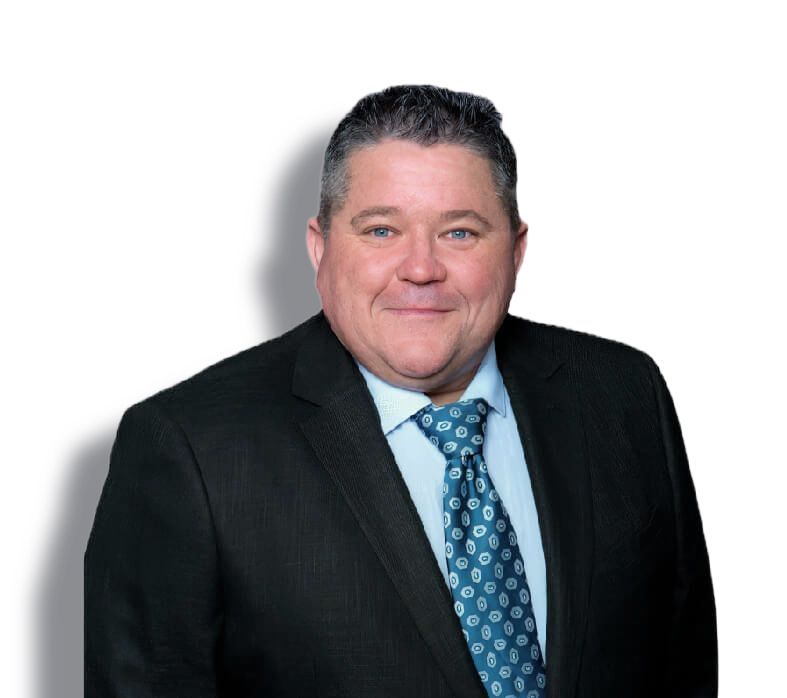 Man in black suit and blue tie smiling against a white background