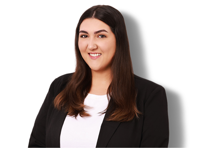 Portrait of a smiling person in a black blazer and white shirt on a white background
