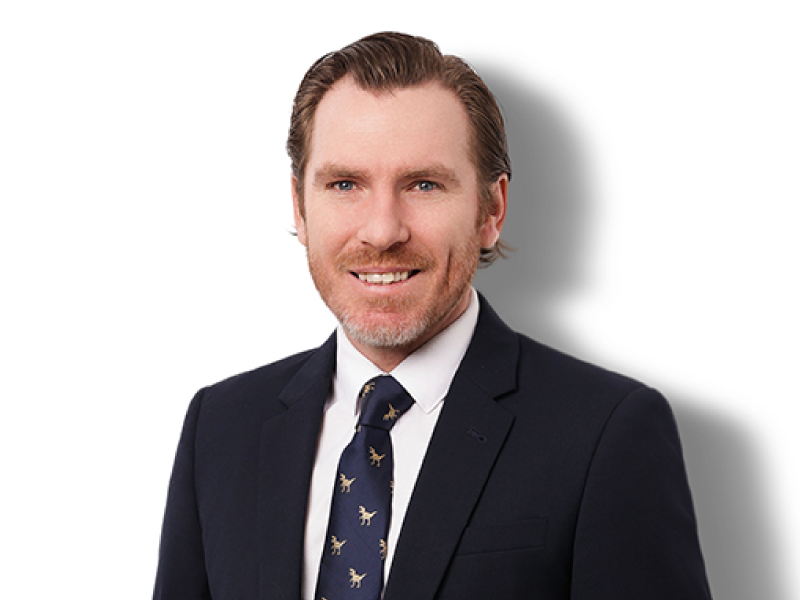 A man in a suit and tie is smiling for the camera.
