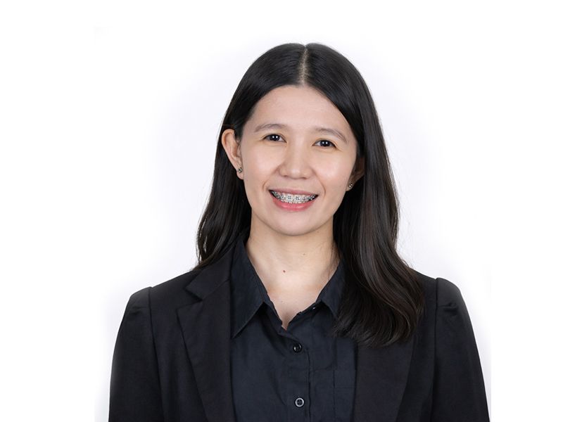 Portrait of a smiling person in a black shirt against a white background