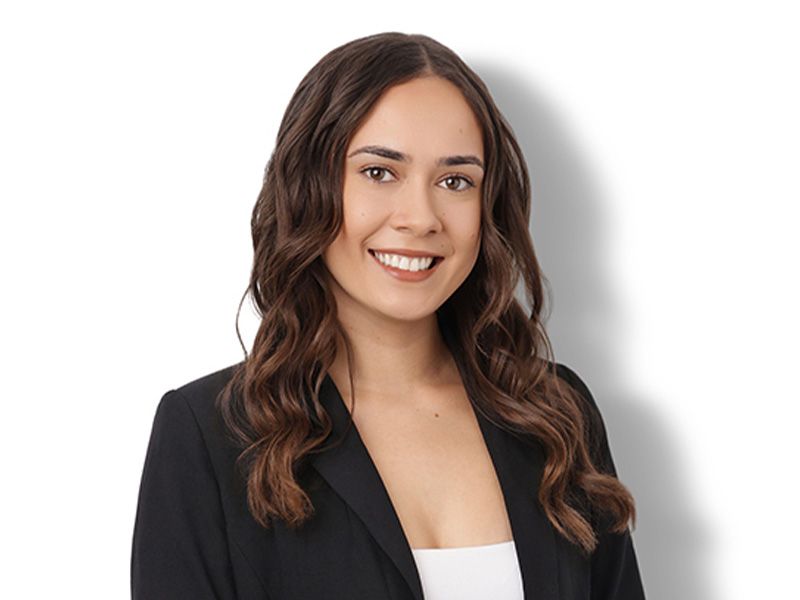 Smiling woman in black blazer against a white background
