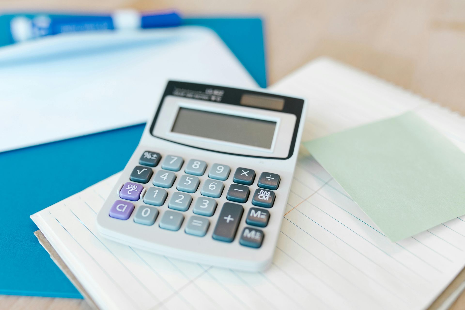 Calculator on a notebook with papers and folders in a bright office setting