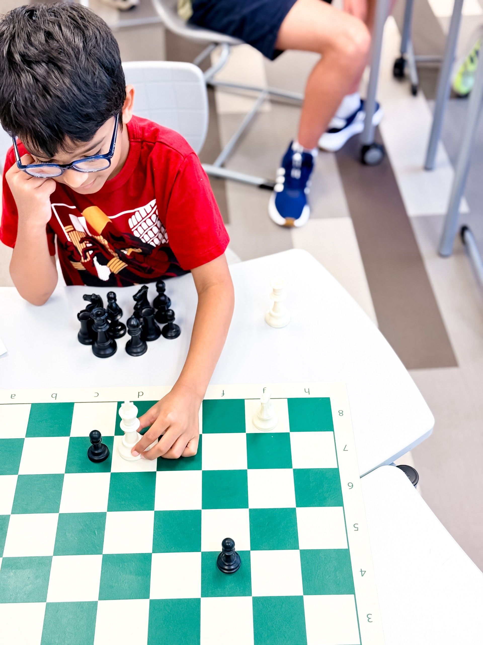 A child playing chess is moving his king.