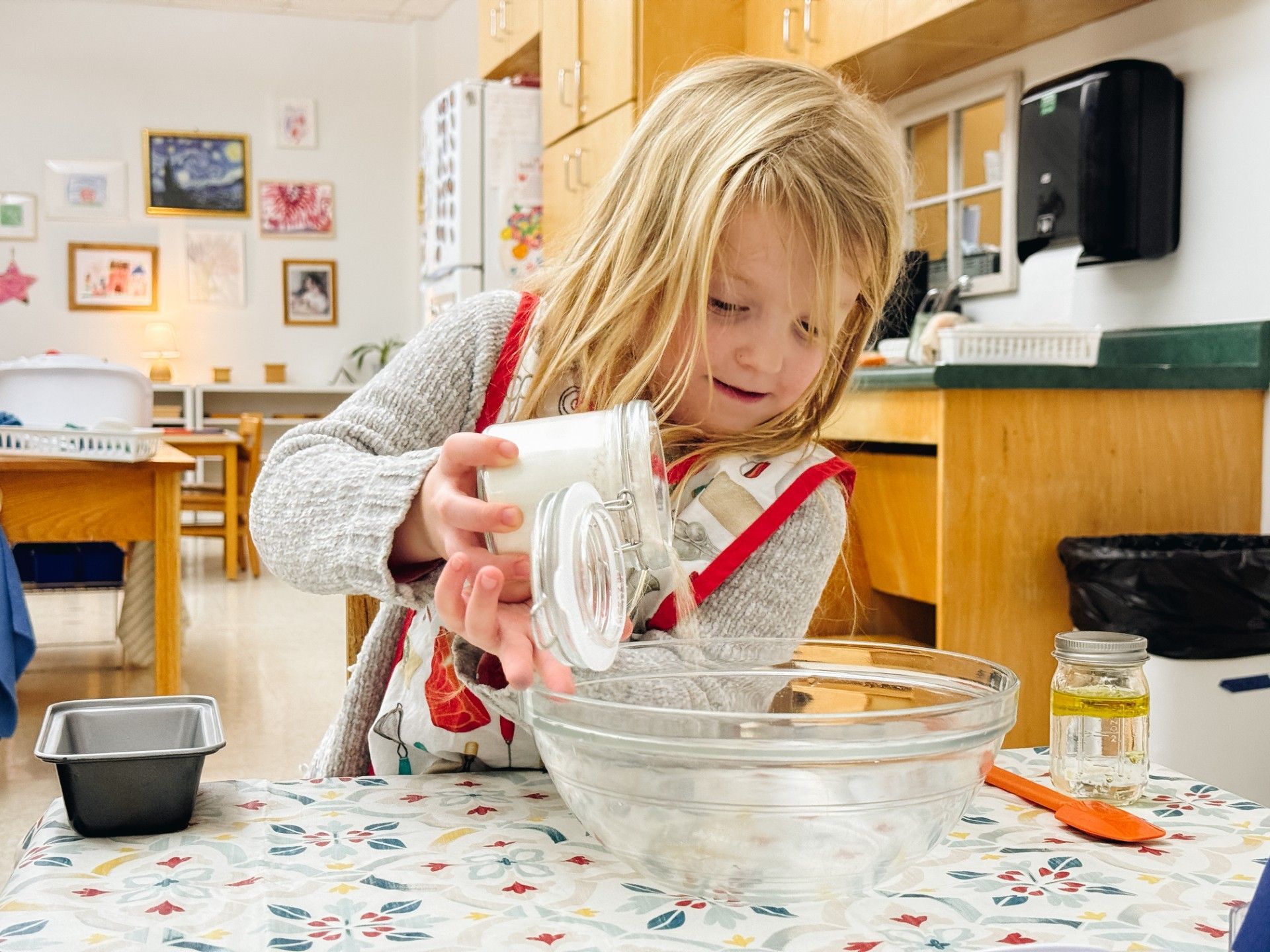 Child pours dry ingredients into bowl to make bread.