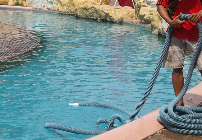 man cleaning a swimming pool man cleaning a swimming pool