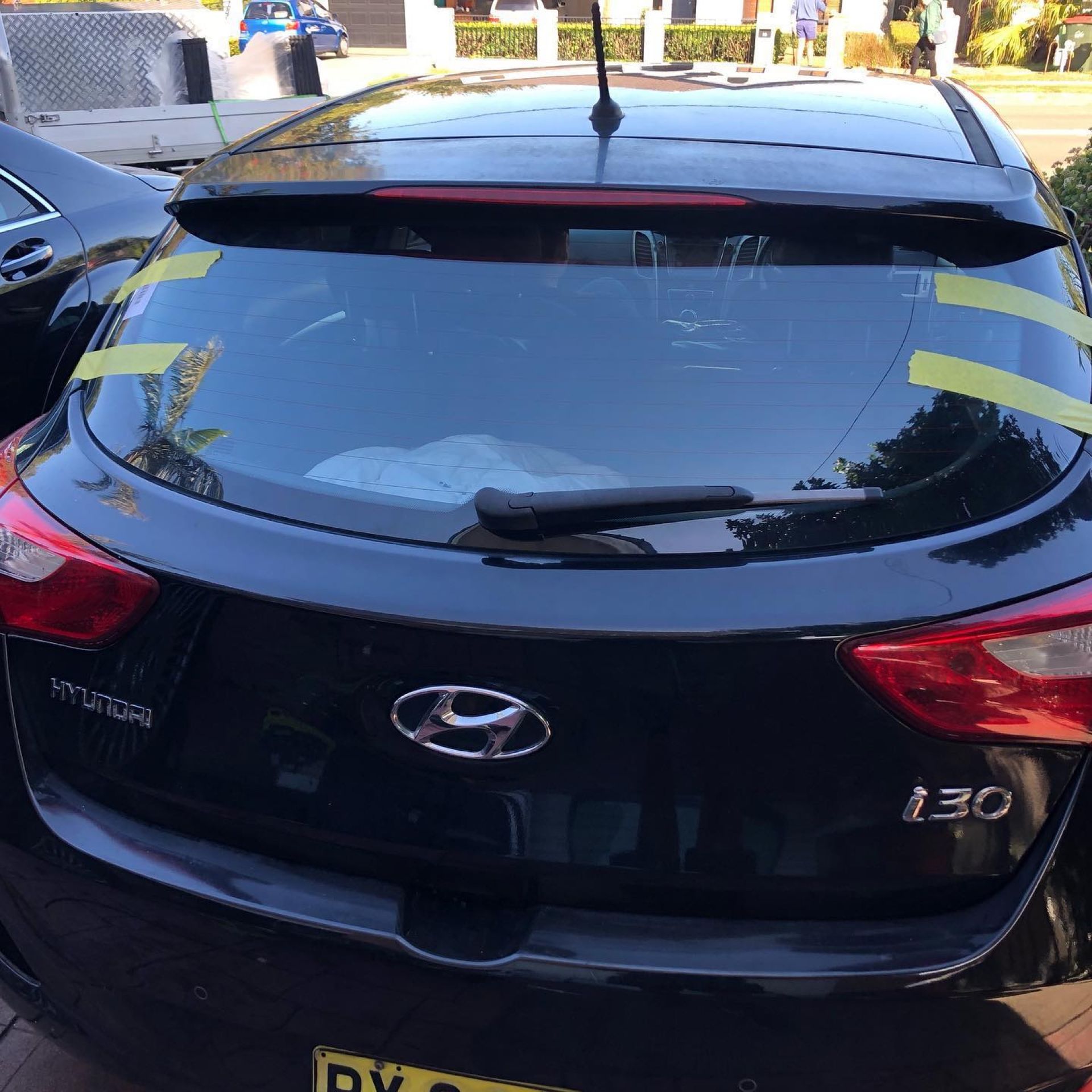 Black Hyundai i30 hatchback parked outdoors, rear view with tinted rear window