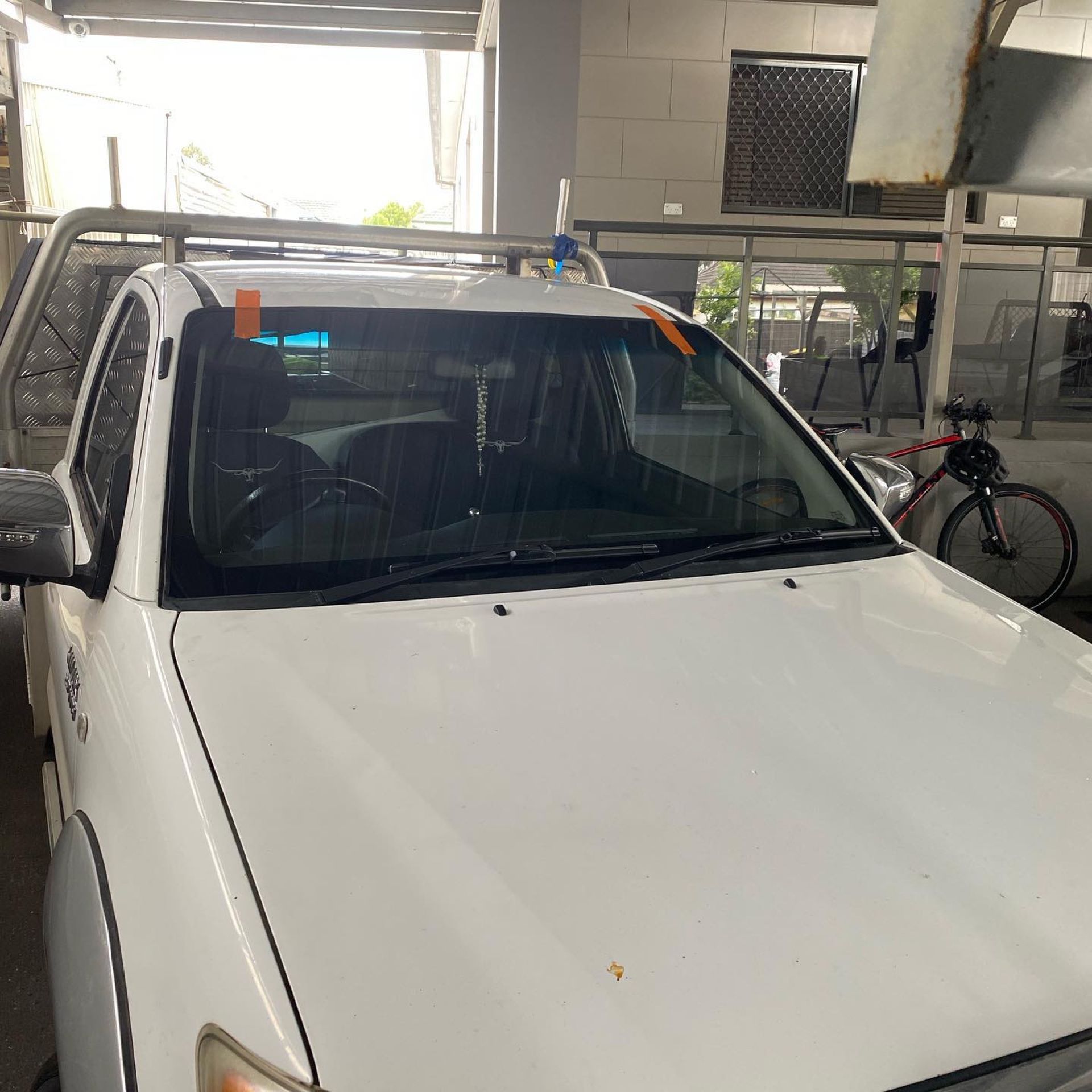 White SUV parked in a covered garage, front view