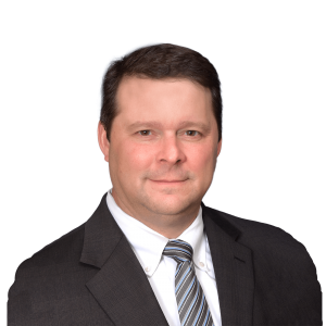 A man in a suit and tie is smiling for the camera.