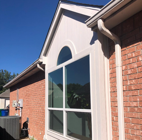 A brick house with a large window on the side