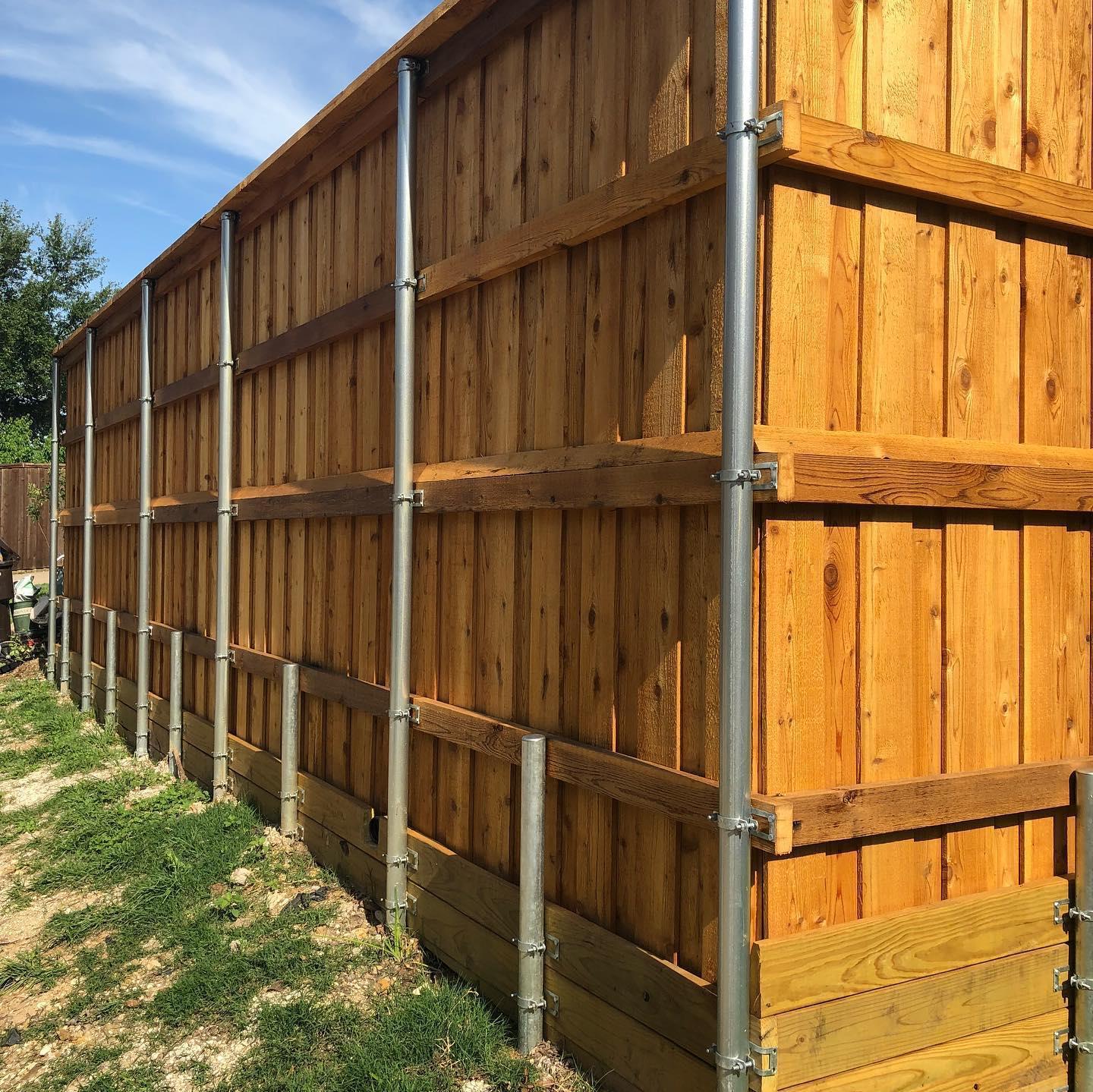 A wooden fence with metal poles attached to it