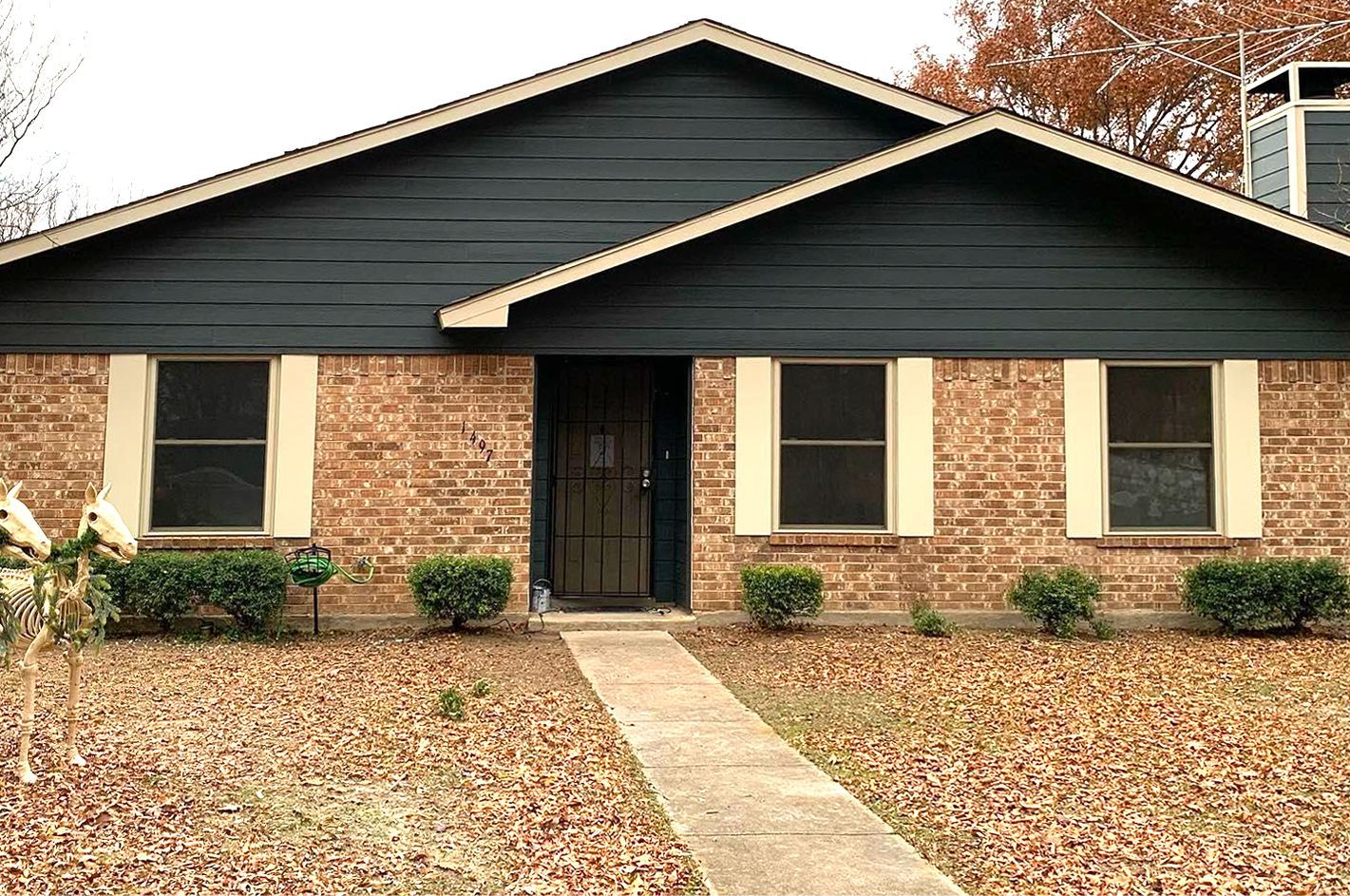 A brick house with a black siding and white shutters
