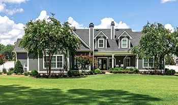 A large house with a large lawn in front of it.