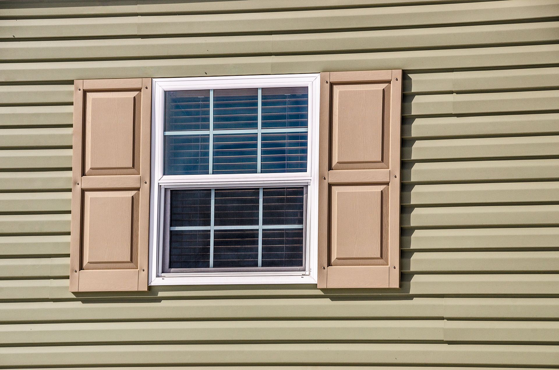 A window with shutters on the side of a house