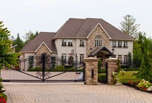 A large house with a gated driveway leading to it.